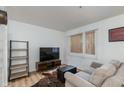 Cozy living room offers wood-look floors, comfortable seating, and a modern entertainment center near a window at 12123 W Bell Rd # 219, Surprise, AZ 85378