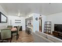 Open-concept living space featuring wood-look floors, dining area, breakfast bar and stainless steel appliances at 12123 W Bell Rd # 219, Surprise, AZ 85378