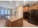 Spacious kitchen featuring a central island with granite countertops, stainless steel appliances, and ample storage space at 12826 W La Vina Dr, Sun City West, AZ 85375