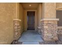 Close-up of the front entrance showcasing stone pillars and a modern screen door at 17531 W Fetlock Trl, Surprise, AZ 85387