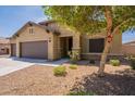 Lovely home featuring a spacious three-car garage and inviting desert landscaping, including a beautiful tree at 17531 W Fetlock Trl, Surprise, AZ 85387