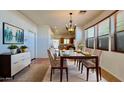 Elegant dining room with a chandelier, large windows, and stylish furnishings at 22507 N 31St Ave # 11, Phoenix, AZ 85027