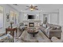 A stylish living room is featuring a fireplace, a cozy seating area, and a large TV for entertainment at 2466 E Aris Dr, Gilbert, AZ 85298