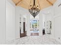 Elegant home foyer with marble floors, soaring ceilings, chandelier, and views into the living room at 30600 N Pima N Rd # 81, Scottsdale, AZ 85266