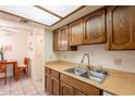 Well-lit kitchen with vintage wood cabinets, double sink, and lots of counter space at 3131 W Cochise Dr # 144, Phoenix, AZ 85051
