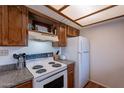 Traditional kitchen with wood cabinets, updated countertops, and white stove appliance at 3131 W Cochise Dr # 269, Phoenix, AZ 85051
