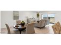 Inviting dining space with stylish furniture and ample natural light from the large windows at 38100 W Bello Ln, Maricopa, AZ 85138