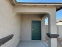 Welcoming front entrance with a stylish dark green door, covered porch, and a decorative pillar at 38100 W Bello Ln, Maricopa, AZ 85138