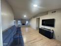 Bright living room features light wood floors, large comfortable sofa, fireplace and entertainment center at 405 E Providence Dr, Casa Grande, AZ 85122