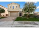 Inviting two-story home with a well-maintained lawn and a charming paver driveway leading to the garage at 4050 S Thistle S Dr, Chandler, AZ 85248