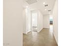 Bright hallway features neutral tile flooring and fresh white walls leading to an open room with carpet at 4167 W Lisa Ln, San Tan Valley, AZ 85144