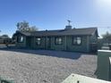 A bright single-story home features an expansive gravel yard, complementing its green exterior and dark gray shingle roof at 4602 N 47Th N Ave, Phoenix, AZ 85031