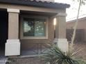 A close-up of a welcoming front porch with decorative columns and a small garden area at 4722 S 238Th Ln, Buckeye, AZ 85326