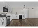 Bright kitchen features white cabinets, dark hardware and stainless appliances over wood-look flooring at 5525 E Thomas Rd # K16, Phoenix, AZ 85018