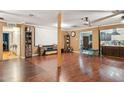Open-concept living room with rich wood floors, featuring a large screen and seamless flow to the kitchen at 5615 W Camelback Rd, Phoenix, AZ 85031