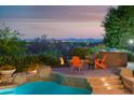 Inviting outdoor space featuring a built-in BBQ, comfortable seating around a fire pit, and a refreshing pool at 5921 E Leisure Ln, Carefree, AZ 85377
