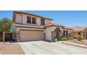 Inviting two-story home featuring a two-car garage and desert landscaping at 597 S 221St Dr, Buckeye, AZ 85326