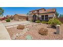 Front exterior of a beautiful home boasting desert landscaping and a charming walkway at 597 S 221St Dr, Buckeye, AZ 85326