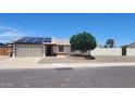 Single-story home with a well-manicured front yard featuring desert landscaping and solar panels at 6104 W Marconi Ave, Glendale, AZ 85306