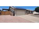 Attached two car garage with solar panels, adjacent to low-maintenance desert landscaping at 6104 W Marconi Ave, Glendale, AZ 85306