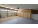 Spacious garage with storage cabinets, a garage door, and overhead lighting at 6104 W Marconi Ave, Glendale, AZ 85306