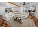 Bright living room with hardwood floors, a large sectional, and seamless flow into the dining area at 6901 E Oak St, Scottsdale, AZ 85257