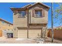 Two-story tan home featuring a two car garage and desert landscaping in front at 823 E Agua Fria Ln, Avondale, AZ 85323