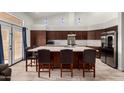 Bright kitchen featuring granite countertops, stainless steel appliances, a large island, and dark wood cabinetry at 1022 S Butte Ln, Gilbert, AZ 85296