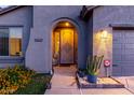 Close up of home entry featuring an arched entryway and desert landscaping at 11829 W Patrick Ln, Sun City, AZ 85373