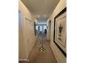 Inviting hallway with neutral tones, decorative art and a stylish rug leading to the living area at 14991 W Shaw Butte Dr, Surprise, AZ 85379
