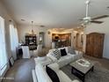 Open-concept living area with a ceiling fan, dining area, and a glimpse of the kitchen at 14991 W Shaw Butte Dr, Surprise, AZ 85379