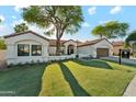 Inviting single-story home with a well-manicured lawn and mature shade trees at 16428 N 59Th St, Scottsdale, AZ 85254