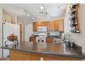 The kitchen area features wood cabinets and an island, all illuminated by track lighting at 17229 N 51St Dr, Glendale, AZ 85308