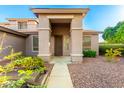 The home's stately front entrance framed by columns and lush desert landscaping at 20432 N 87Th Dr, Peoria, AZ 85382
