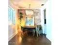 Bright dining room featuring a modern light fixture, exposed brick wall, and sleek flooring at 2335 W Campus Dr, Phoenix, AZ 85015