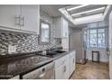 Well-lit kitchen featuring stainless steel appliances, neutral tiling, and under cabinet lighting at 2335 W Campus Dr, Phoenix, AZ 85015