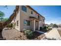 Inviting two-story home with a covered entry, desert landscaping, and a well-lit walkway at 2668 N 73Rd Gln, Phoenix, AZ 85035
