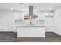 An all-white kitchen features a large island, modern backsplash, and bright lighting at 3002 W Mandalay Ln, Phoenix, AZ 85053