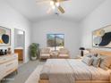Serene bedroom showcasing neutral tones, modern furniture, and ample natural light, complete with an ensuite bathroom at 40168 W Sanders Way, Maricopa, AZ 85138