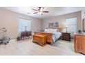 Primary bedroom with light hardwood floors, ceiling fan, and a bright window at 42406 W Posada Dr, Maricopa, AZ 85138
