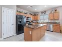 This kitchen features an island, stainless steel appliances, and light wood cabinets at 42406 W Posada Dr, Maricopa, AZ 85138