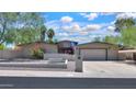 Charming single-story home featuring a large driveway, desert landscaping, and an American flag proudly displayed at 511 E Port Au Prince Ln, Phoenix, AZ 85022