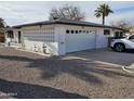 Single story home features a two car garage and unique privacy screen details at 5728 E Dodge St, Mesa, AZ 85205