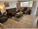 Cozy living room features neutral tile floors, comfortable seating, and a large window at 5728 E Dodge St, Mesa, AZ 85205