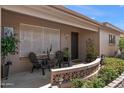Inviting covered front porch with seating area and desert themed decorations, perfect for relaxing at 6448 E Des Moines St, Mesa, AZ 85205