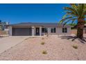 Charming single-story home featuring a two-car garage and desert-style landscaping for easy maintenance at 6944 E Gary Cir, Mesa, AZ 85207