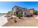 Exterior view of the home with desert landscaping in front of house at 8208 W Albeniz Pl, Phoenix, AZ 85043