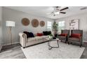 Bright living room featuring a neutral-toned sofa, armchairs, and stylish decor at 8208 W Albeniz Pl, Phoenix, AZ 85043
