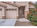 View of the home's front exterior with desert landscaping, a three-car garage, and a covered entry at 8766 W Hayward Ave, Glendale, AZ 85305