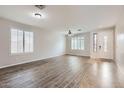 Bright living room featuring wood-look flooring, plantation shutters, and fresh paint at 8766 W Hayward Ave, Glendale, AZ 85305